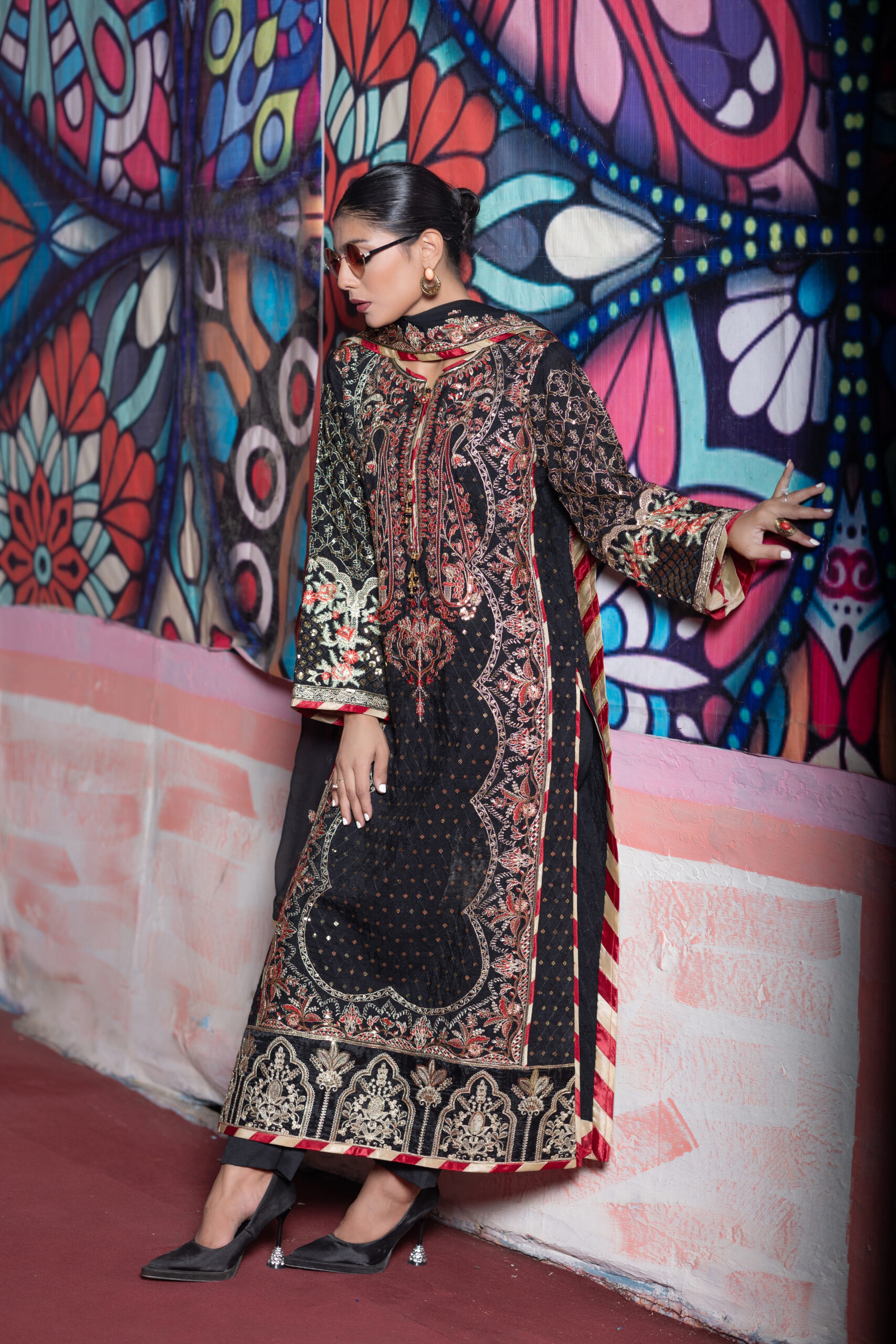 Black 3-piece embroidered silk suit with chiffon dupatta and macro trouser styled with statement earrings and black heels.