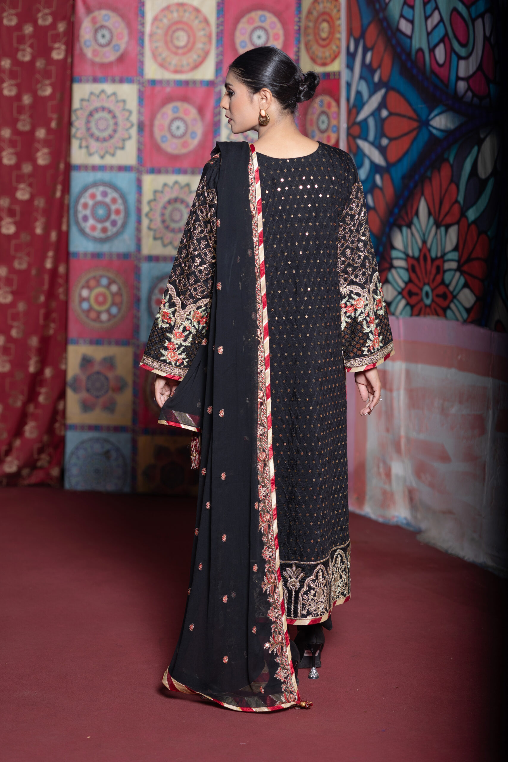 Black 3-piece embroidered silk suit with chiffon dupatta and macro trouser styled with statement earrings and black heels.